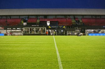 General view of football pitch to main stand taken from the north west. Under floodlights.