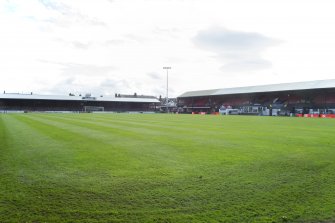 General view of the football pitch to the main stand and east covered terracing taken from the north west.