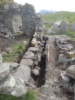 Excavation, Trench 2, post-excavation, oblique shot of S-facing section of wall 004, Teampull na Trionaid, Cairinis, North Uist, Western Isles