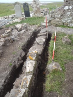 Excavation, Trench 2, post-excavation, oblique shot of N-facing section of wall 004, Teampull na Trionaid, Cairinis, North Uist, Western Isles