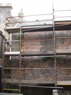 View of exposed stonework and bricked-up openings on east elevation of 21 Queen Anne Street, Dunfermline.