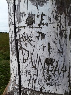 Close-up view of some of the graffiti on the post.