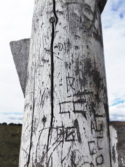 Close-up view of some of the graffiti on the post.