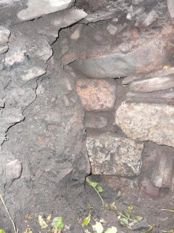 SW wall face, with loose backfill mixed deposits to left, above wall is orange ash deposit then rubble of broch outer wall