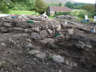 In foreground, compacted rubble and earth of possible later ramp corresponding to linear bank exposed in 2008, in background, outer wall and outer outer