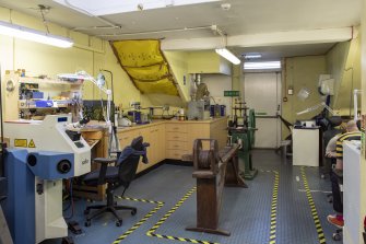 Interior. Third floor. Goldsmiths workshop. View of work benches and a probable 19th century, hand-operated, wire straightening/ drawing machine.