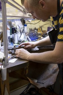 Interior. Third floor. Goldsmiths workshop. Detail of goldsmith working at his bench.