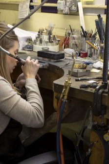 Interior. Third floor. Goldsmiths workshop. Detail of the goldsmith at her traditional bench. 