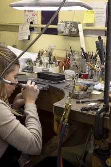 Interior. Third floor. Goldsmiths workshop. View of the goldsmith at her traditionally laid out bench.