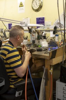 Interior. Third floor. Goldsmiths workshop. View of goldsmith carrying out the technique of soldering.