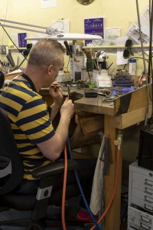 Interior. Third floor. Goldsmiths workshop. View of goldsmith carrying out the technique of soldering.