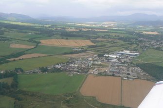 Aerial view of Muir of Ord, oblique view of industrial estate and part of Black Isle showground, looking NW.