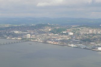 Oblique aerial view of the W part of Dundee waterfront, the city centre and Dundee Law, backed by the Sidlaw Hills, looking NW.