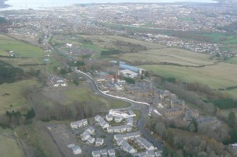 Oblique aerial view of Craig Dunain Hospital Building with Inverness and the Kessock Bridge, looking NE.