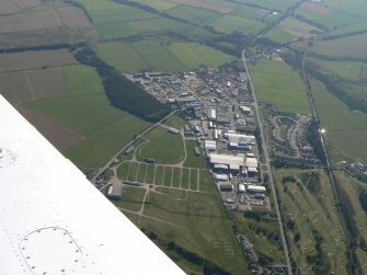 An oblique aerial view of Muir of Ordnear Muir of Ord, Black Isle, looking S.