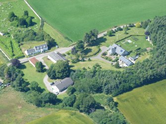 Near vertical aerial view of houses and Urquhart Old Parish Burial Ground, Black Isle, looking N.