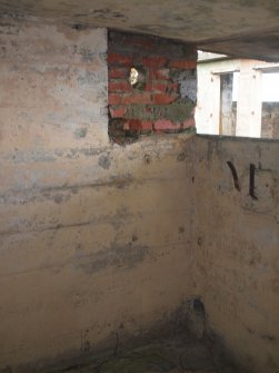 The secondary brick blocking on the NE side of the observation window in the compartment in the central tier of the building