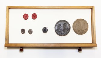 View showing contents of fourth drawer from the top of cabinet containing intaglios and wooden plaques.