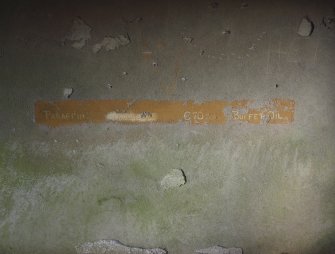 A painted notice on the inside of the SE wall of the gun store