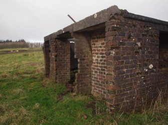 View from the SE of the upstanding brick and concrete structure (NS 54352 77171) bridging a gap between two long Nissen hut platforms