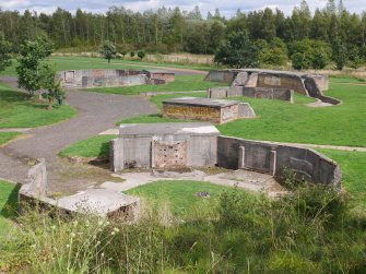 View from the W overlooking the SW gun-pit (NS 68150 59837), with the crew shelter of the S gun-pit (NS 68175 59837) in the middle distance and the SE gun-pit (NS 68200 59840) and SE magazine beyond (NS 68197 59817)