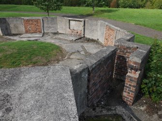 The SE entrance to the SE gun-pit (NS 68197 59817) with the remnants of three demolished ammunition lockers against the pit wall on the ENE side
