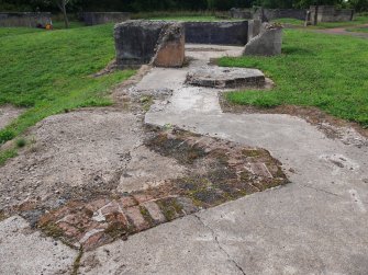 View from the ESE of the remains of the enclosures provided for the predictor, the telescope and the height finder situated NE of the command post