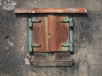 A small steel shuttered window to the left of the double-door in the E elevation of the magazine forming part the NW gun emplacement (NS 45132 57213)