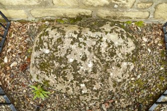 View of cup and ring marked stone below east window. Photographed in daylight.