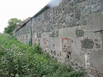 Historic building survey, E exterior wall of cattle-byre showing bricked-up vents and adjoining E exterior wall of apartments M and N, The Steading, Eastfield Road, Edinburgh