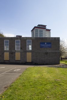 West view of church from car park showing signage and tower blocks to east