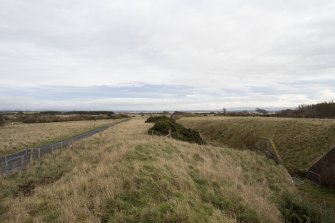 General view from west showing road and railway embankment. Taken from north side of World War 2 magazine R60.