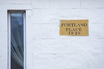 Detail of street sign reading 'Portland Place 1828' on north facade.