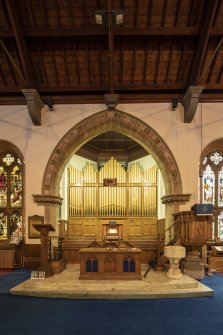 View of platform with lectern, communion table, font, pulpit and organ. 