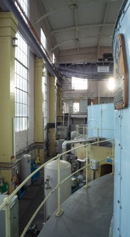 Interior. Carsfad  Hydro Electric Power Station. Turbine/Power House. View from west along south side of building towards Operating Room at mezzanine level. The generator sets, Units 1 and 2, on the right