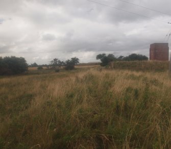 Unbuilt Explosives Magazine at Hill 1: view from the ESE of the embankment of the narrow gauge railway line as it approached the site of Nitroglycerine Hill I, with the brine tank tower in the background