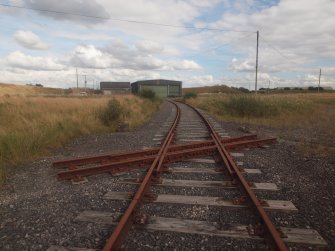 View from the SE of a Narrow Gauge and a Standard Gauge railway crossing (NY 25368 64684) W of the main transit building (Y17)