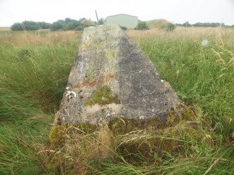 View from the N of an isolated block of probable World War 1 concrete (NY 26492 64165) showing its truncated pyramidical cross-section, with Explosives Magazine R52 in the background