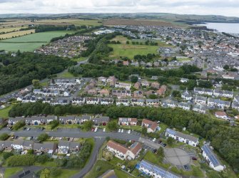 Oblique aerial view from east showing Modern (Gunsgreenhill), Mid- to Late C20 (The Avenue), Victorian Expansion, Mid- to Late C20 (Gillsland) and Historic Burgh and Harbour Areas of Townscape Character, Eyemouth