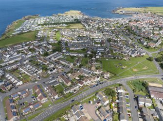 Oblique aerial view from south-west showing Modern (Acredale), Mid- to Late C20 (Deanhead), Mid- to Late C20 (Barefoots), Inter-War (Hurkur Crescent and Schools) and Recreation (Holiday Park) Areas of Townscape Character, Eyemouth