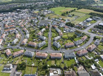 Oblique aerial view from north-west showing Inter-War (Hurkur Crescent and Schools), Mid- to Late C20 (Barefoots) and Industrial (Acredale and Eyemouth Industrial Estates) Areas of Townscape Character, Eyemouth