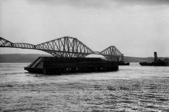 Rosyth Dockyard: Tugs taking charge of the launch of one of the seven sliding dock caissons designed and built by Arrol for the Admiralty, en route from the construction site at North Queensferry to Rosyth Dockyard, circa 1914