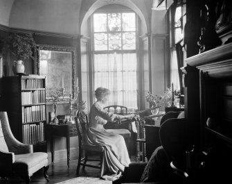 Interior.
View of bay window in drawing room showing Mrs Paterson with her embroidery.