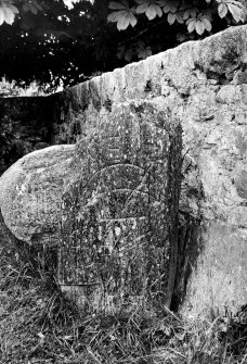 Inverallan Pictish symbol stone bearing crescent and V-rod and notched rectangle and Z-rod. Behind it a 'font'.
Original negative captioned: 'Sculptured Stone and Font, Inverallan, Grantown, Inverness. 1910'.