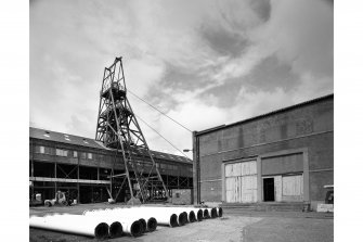 View form South East of headstock and winding engine house (with pipes ready to be taken down the mine in foreground).