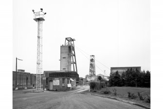 General view from W of weighbridge, 100,000 gallon water tank, no. 2 shaft headframe and winding engine house, and no. 1 shaft headframe.
