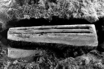 View of coped graveslab to SE of church bearing two parallel graves in its upper surface.