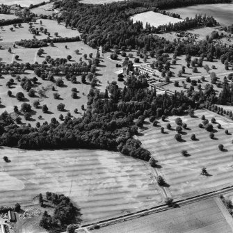 Mains of Glamis and Glamis Castle, oblique aerial view, taken from the E, showing a pair of linear cropmarks in the bottom half of the photograph, and further cropmarks in the bottom right-hand corner. Glamis Castle is visible in the centre.