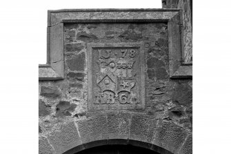Heraldic panel over arch.