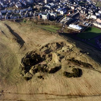 Oblique aerial view of Holyrood Park centred on the remains of quarries, taken from the ESE.